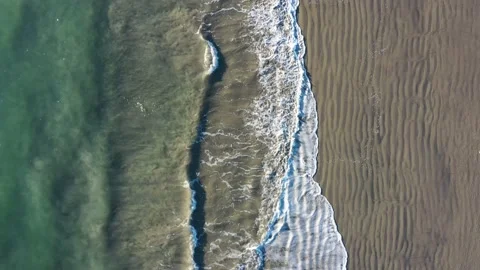 Drone Aerial With Camera Facing Downward Flying Parallel With Waves Along Bea Video stock 196015213