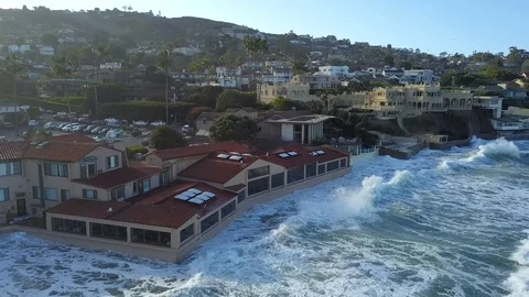 Drone aerial capture of huge waves crashing into beachfront restaurant San Diego Stock Footage 101577715