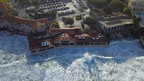 Drone aerial capture of huge waves crashing into beachfront restaurant San Diego Stock Footage 101578984
