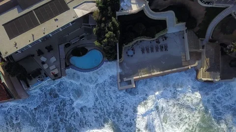 Drone aerial capture of huge waves crashing into oceanfront homes in San Diego Stock Footage 101579328