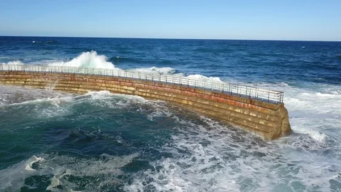 Drone aerial capture of huge waves crashing into sea wall in San Diego Stock Footage 101580933