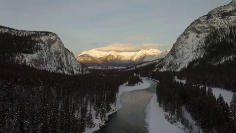 Drone aerial fly over of river snow covered banff mountains Stock Footage 83993341