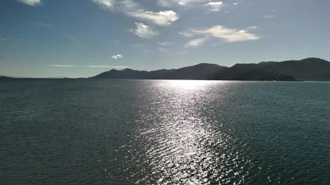 Drone aerial forward flight video over calm ocean with sun reflection in Santa Stock Footage 316361248
