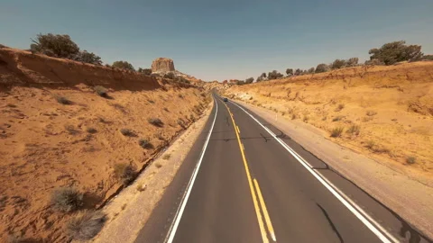Drone aerial fpv chasing a car on a desert road with buttes and canyons Video stock 165042162