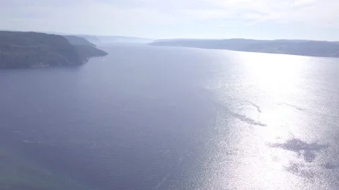Drone aerial high angle tracking over fjord with glistening ocean below. Stock Footage 169302782