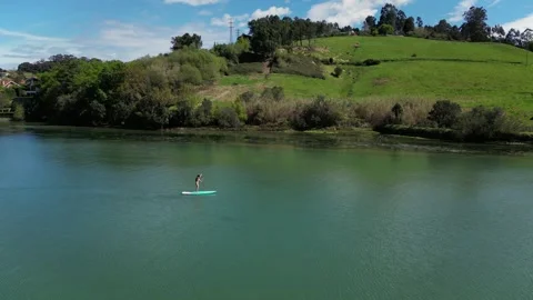 Drone aerial left to right panning Latin woman in bikini paddle surfing on .. Stock-Footage 271099575