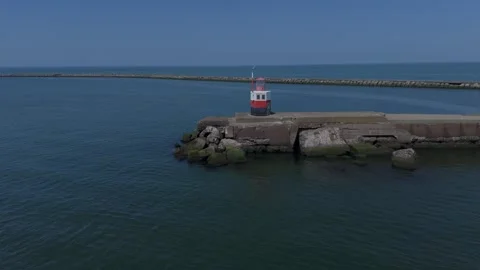Drone aerial of lighthouse on harbor pier by the sea Video stock 337351378