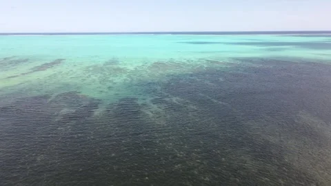 Drone aerial moving forward and panning down over a blue ocean in New Caledonia Stock Footage 319060080