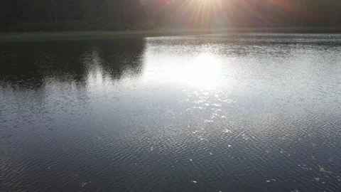 Drone aerial moving slowly low above a small lake reflecting the early morning Stock Footage 312945267