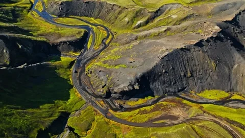 Drone aerial over a braided river cutting through bright mossy Icelandic Stock Footage 331077027