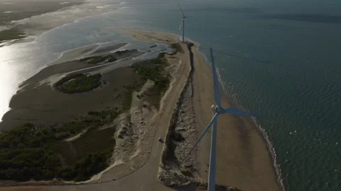 Drone aerial over coastal barrier spit with wind turbines near Ilha do Guajiru Stock Footage 334256953