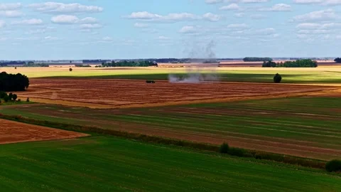 Drone aerial over patchwork farmland with green fields and freshly harvested Stock Footage 333313802