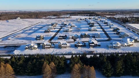Drone aerial over a snow-covered suburban subdivision with new single-family Stock Footage 325832965