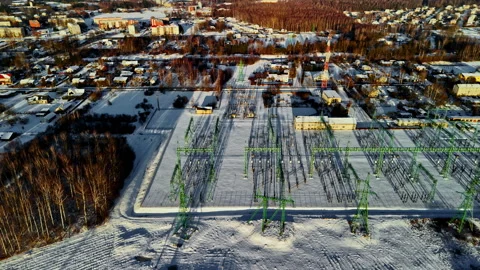 Drone aerial over a snowy electrical substation and switchyard, green steel Video stock 326291883