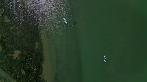 Drone aerial Overhead shot of two young Latina girls paddle surfing on a rive Stock Footage 271099662