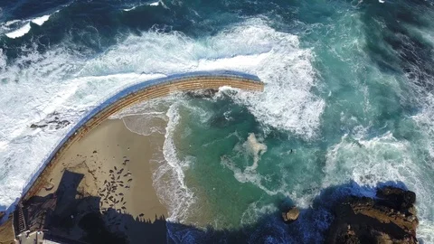 Drone aerial overhead view of huge waves crashing into sea wall in San Diego Stock Footage 101581475