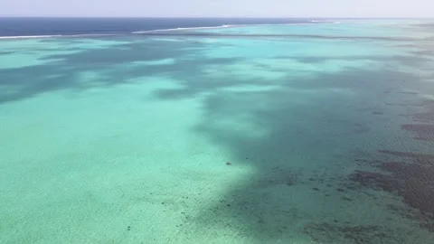 Drone aerial pan down over a blue reef on a cloudy day in New Caledonia Stock Footage 319059075