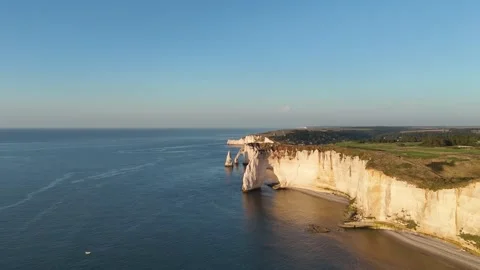 Drone aerial pan over dramatic white chalk cliffs at golden hour, Etretat Stock Footage 346477158