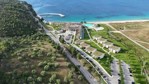 Drone aerial panorama of beachfront resort complex and turquoise sea Greece Stock Footage 327790053