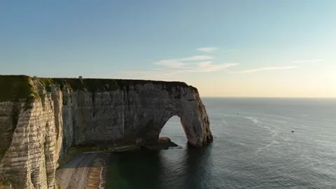 Drone aerial pull back reveals dramatic natural stone arch at golden hour Stock Footage 346477106