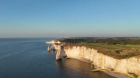 Drone aerial pullback over white chalk cliffs and turquoise sea at golden hour 動画素材 346477073