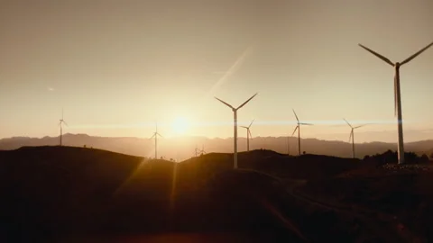 Drone aerial push in of wind turbines. sunset over hills renewable energy farm Vidéo 333364181