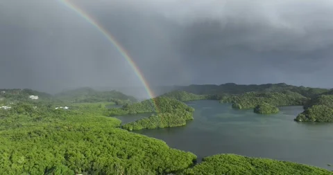 Drone aerial of a rainbow above idyllic lush pacific island group Stock Footage 332704509
