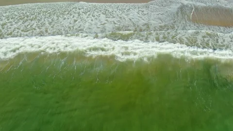Drone aerial of rolling waves crashing onto the beach Stock Footage 260374214