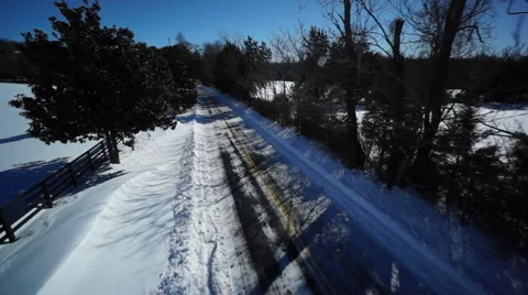 Drone aerial shot of Flight Down Snowy Country Road after winter storm Stock Footage 68450114