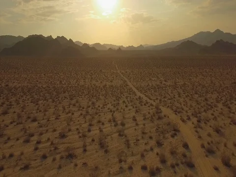 Drone aerial shot flying low over desert into sunset 2.39:1 aspect ratio Stock Footage