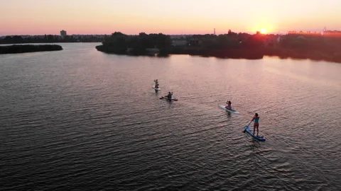 Drone aerial shot of people on paddle boards on river on sunny summer day Stock Footage