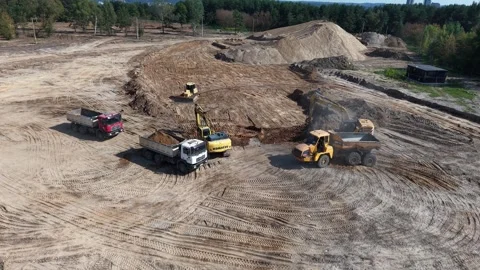 Drone aerial shows excavator loading dump trucks and a bulldozer shaping sand Video stock 327791006