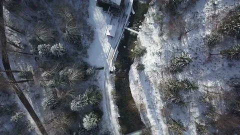 Drone aerial top down view of river through the white snowy forest in winter Stock Footage 148497324