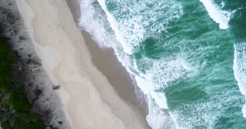 Drone aerial top down view of the ocean swell on the shore of a beach with .. 스톡 동영상 310247504