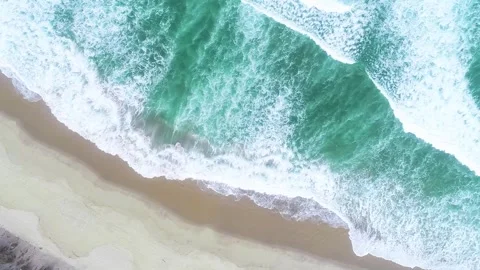 Drone aerial top down view of the ocean swell on the shore of a beach with .. 스톡 동영상 310247505