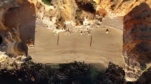 Drone Aerial top down view of people walking on the beach of Praia Dona Ana Stock Footage 318846899