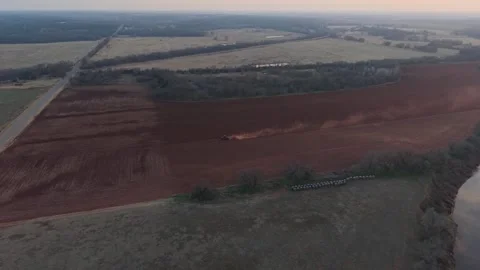 Drone Aerial Tractor Plowing Red Dirt Field Beside Creek Oklahoma Stock Footage 330128367