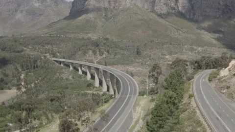 Drone aerial traffic passing on elevated road in mountain valley Stock Footage 277386348