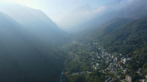 Drone aerial view of an alpine mountain village and forest on a foggy day Stock Footage 215875512