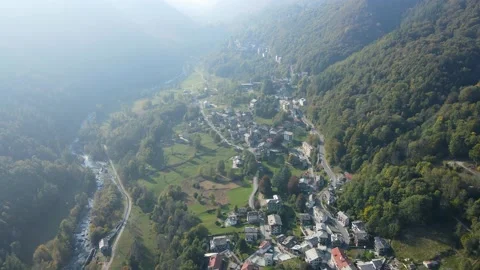 Drone aerial view of an alpine mountain village and forest on a foggy day Stock Footage 215875552