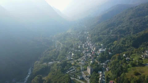 Drone aerial view of an alpine mountain village and forest on a foggy day Stock Footage 215875758