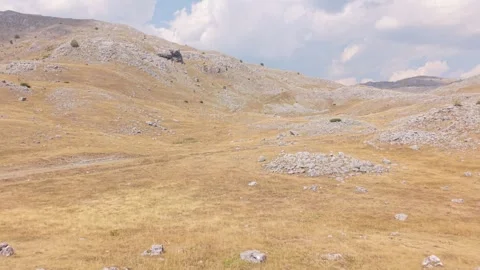 Drone Aerial View of Arid Mountain Landscape with Dry Yellow Grass, Rocky Hills  Stock-Footage 343676060