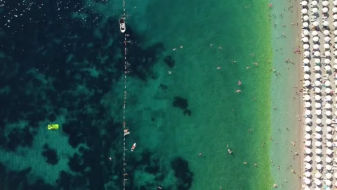 Drone aerial view of a beach filled with people on a hot summer day Stock Footage 262178122