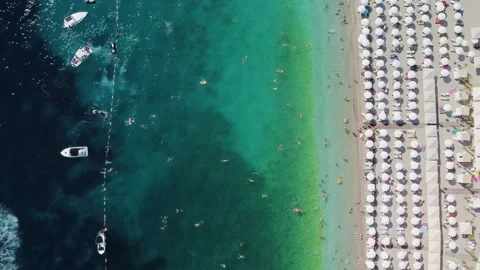 Drone aerial view of a beach filled with people on a hot summer day Stock Footage 289639515