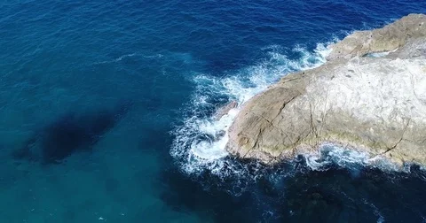 Drone Aerial view of Blue Ocean Crashing into Rocks Stock Footage 78320233