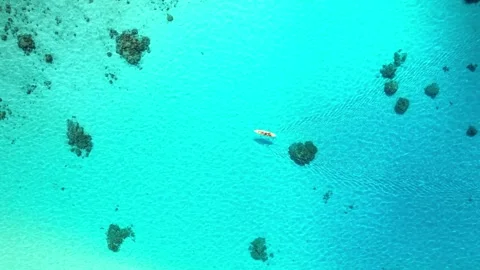 Drone aerial view Bora Bora Tahiti. Kayak in blue lagoon, coral reef seen  Stock Footage 252236369