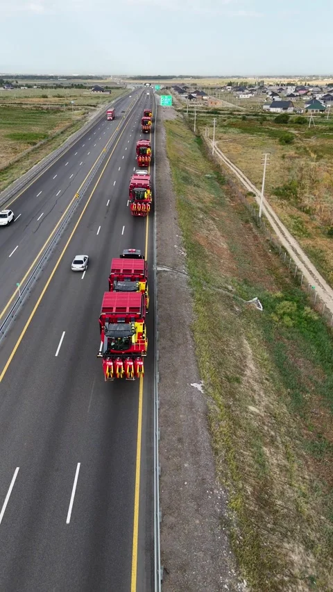 Drone aerial view of convoy transporting combine harvesters on multi-lane Stock Footage 339637932