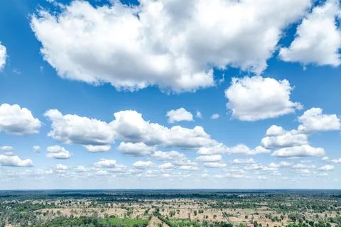 Drone aerial view of dramatic white cumulus clouds floating across a bright.. Stock Photos