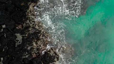Drone aerial view of empty coast with ocean waves splash against rock background Stock Footage 231137593