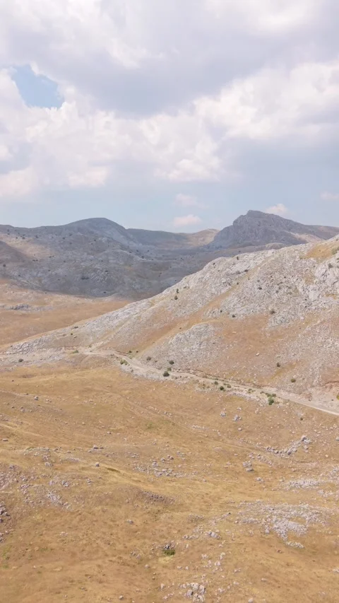 Drone Aerial View Flying Across Arid Mountain Peaks and Dry Valley Landscape  Stock Footage 343672145